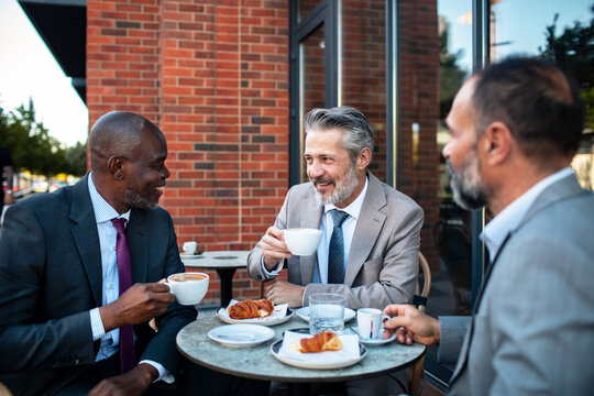 Three business colleagues having coffee at outdoor cafe