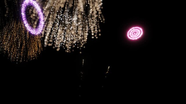 A dynamic display of colorful fireworks exploding into starburst patterns and symmetrical light effects in a darkened sky. 3D Render