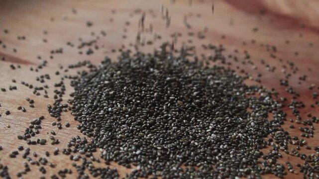 chia seeds falling into a wooden bowl