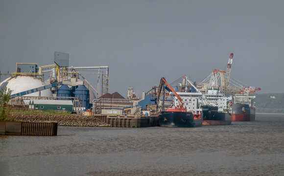 Quebec City, QC, Canada. July 30, 2026. Wide angle view of cargo cargo ships docked at an industrial harbor facility along the river.