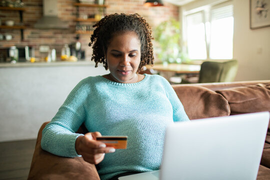Woman using credit card for online shopping at home