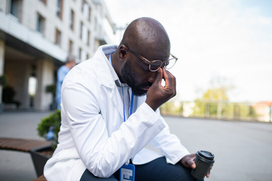 Stressed doctor with coffee taking break outdoors