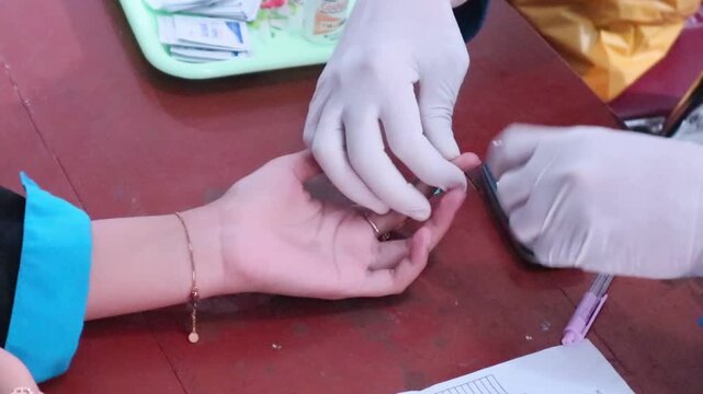 Doctor performing a blood test (for diabetes and high cholesterol). 