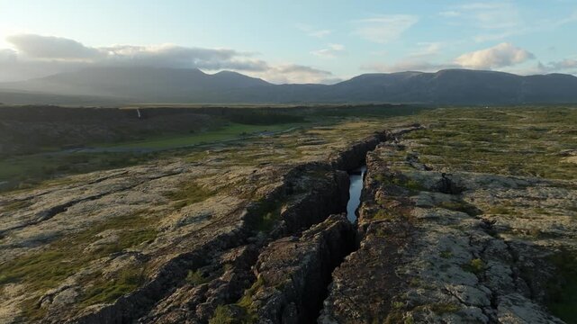 A stunning aerial drone push in shot revealing the stunning Almannagj&aacute; rift valley in Thingvellir National Park on Iceland, showcasing its rugged beauty.