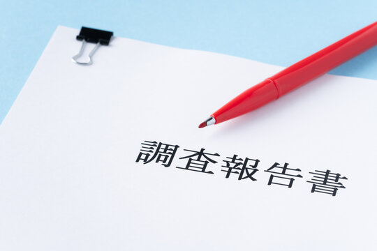 水色背景に調査報告書と赤いペン