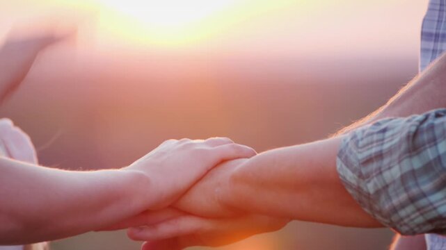 Family joining hands together in unity and harmony during beautiful sunset.