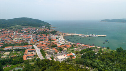 Naklejka premium Coastal Fishing Village With Harbor On Sunny Day