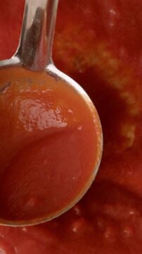 Fresh tomato sauce being stirred with a metal spoon