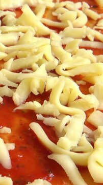 Fresh Pizza Dough Being Topped With Tomato Sauce and Mozzarella Cheese