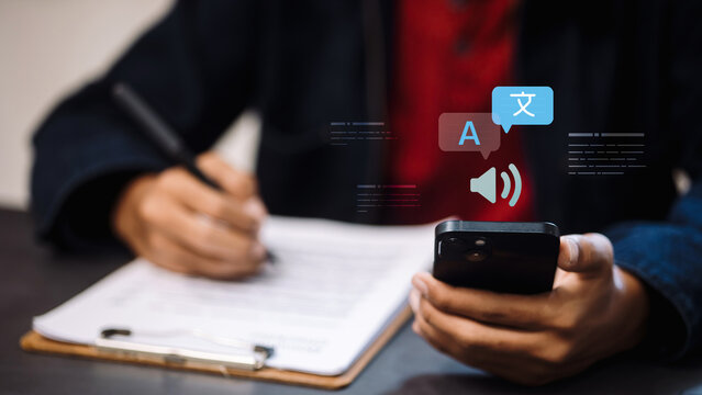 Person Hands Writing Document and Holding Smartphone with Language Translation and Voice Icons Graphic