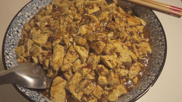 Close Up Bowl of Vegetarian Mapo Tofu with Sichuan Spices and Rich Sauce