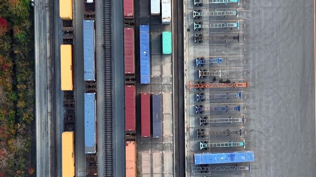 Aerial top down view of freight trains with shipping containers moving