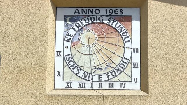 Historic sundial with Alemannic (A German Dialect) inscription on a building wall.