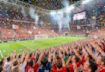 Fototapeta premium Blur image of soccer supporters celebrating with smoke flares and flags during a football match.