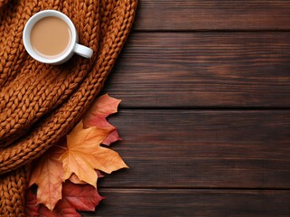 Autumn cozy coffee with a brown scarf and maple leaves on a rustic wooden fall desk