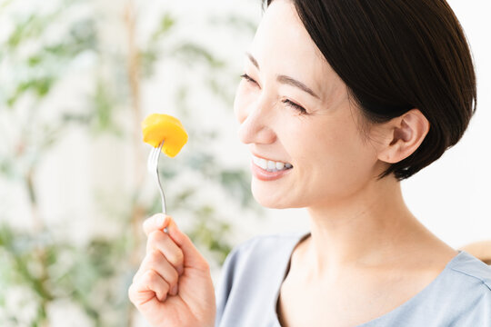 柿を食べる女性　食べ物イメージ