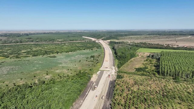 Highway infrastructure project with earthworks, soil compaction and gravel transport for modern civil engineering
