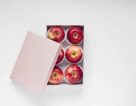 Top view of fresh red apples in a pink gift box