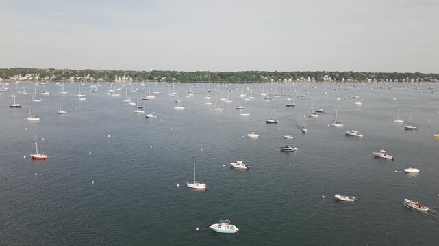 Aerial shots of boats and yachts in the harbor in Salem, Massachusetts on a warm summer day. Ocean views with panning shot.