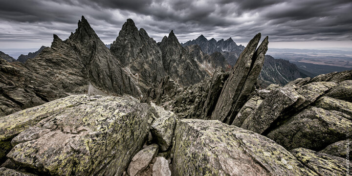 Rocky ridge dramatic sky mountain peak sharp summit rugged terrain dark cloud stone cliff epic landscape remote wilderness dangerous place under stormy cloud create powerful mood