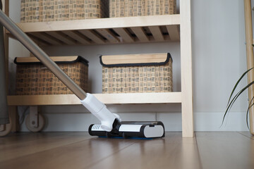 Vacuum cleaner in action on wooden floor
