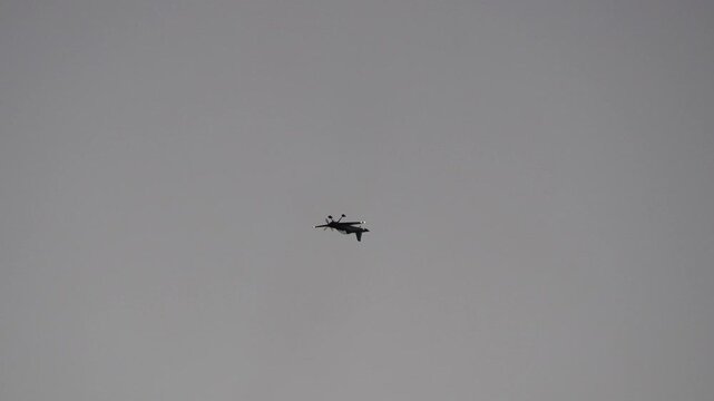 Silhouette of a propeller plane performing an aerobatic loop with smoke trail
