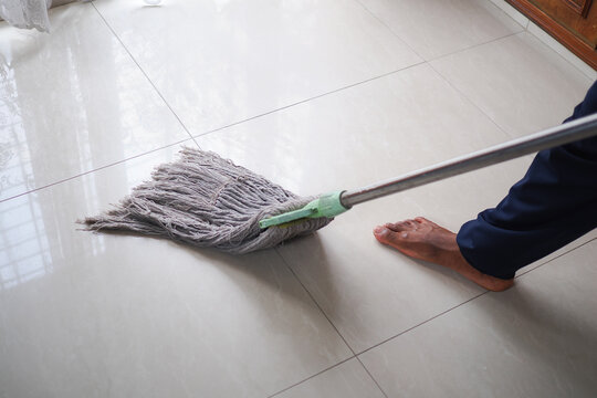 Person mopping floor in a room with light