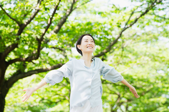 木の下でストレッチをする若い女性　ライフスタイルイメージ