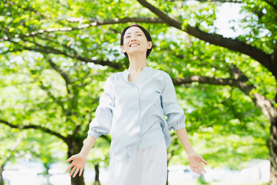 木の下でストレッチをする若い女性　ライフスタイルイメージ