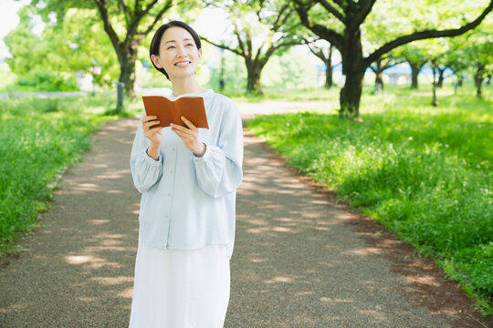 屋外で読書をする若い女性　ライフスタイルイメージ