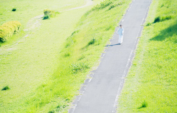 散歩道を歩く若い女性　ライフスタイルイメージ