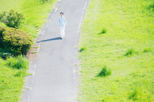 散歩道を歩く若い女性　ライフスタイルイメージ