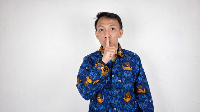 Young male civil servant making a shut up gesture in white background