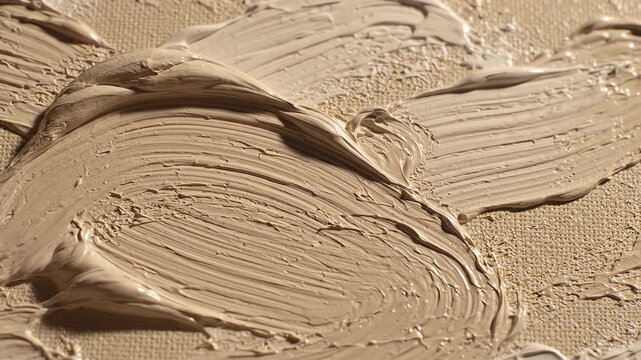 Macro view of thick beige oil paint strokes moving across textured canvas creating an abstract tranquil landscape background