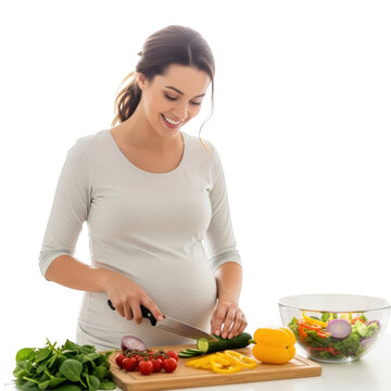 Pregnant woman cutting vegetables on board.