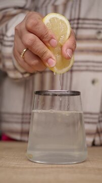 Squeezing lemon juice into a glass of water