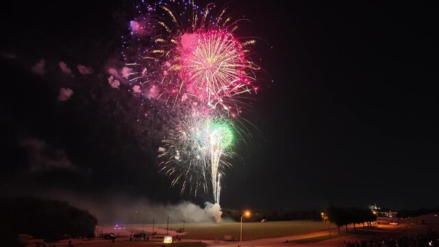 Colorful fireworks exploding over a park at night