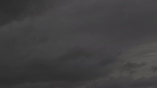 Dark gray storm clouds gathering across the sky during a gloomy overcast afternoon before heavy rain