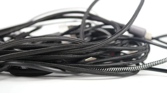 Wires and cables are tangled on a white surface