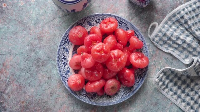 Java Apple, also known as a Rose Apple, Water Apple on a blue and white plate