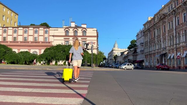 Odesa, Ukraine - June 29, 2026: Woman traveler crosses pedestrian crossing