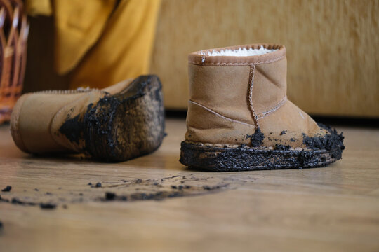 close-up of worn brown leather boots on a wooden floor in an indoor setting, casual everyday use, commercial fashion context, natural light, clean background, copy space, modern design, web.