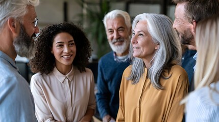 Fototapeta premium A diverse group of adults engaged in friendly conversation in an indoor setting with natural lighting