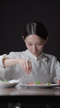料理の盛り付けをする女性シェフ
