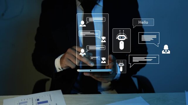 Businessman using a tablet with hologram chat icons and a virtual chatbot interface in a dark office, Holographic online customer support, messaging, and digital communication technology