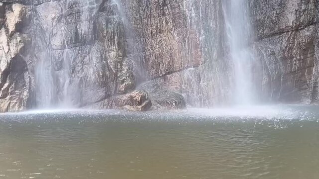 Horizontal view of bottom plunge pool of Diyaluma waterfall in Sri Lanka where high cascading water transforms into airborne mist spray over water