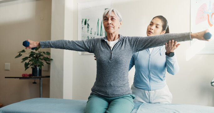 Physio, old woman and stretching for checkup with dumbbells, assessment and mobility recovery. Physiotherapist, help or senior person in office for physical therapy, fitness and muscle rehabilitation