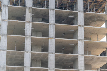 Obraz premium Construction of a multistory building showing concrete columns and unfinished floors in an urban setting during daylight