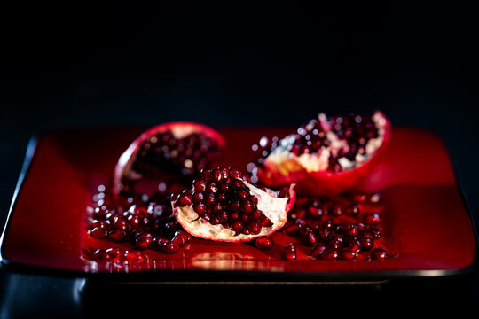 Pomegranate with seeds. Ripe red pomegranates arils with scattered seeds. Pomegranate grains. Pomegranate seeds.