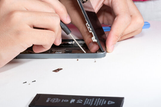 The smartphone was damages and need to repair which tools smartphone that stand isolated on white background by hands of repairman.	